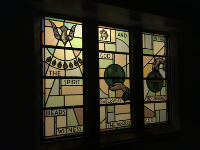 Three stained glass panels, geometric shapes and words 
